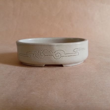 Piccolo vasso ovale in gres smaltato, con nuvole stilizzate incise sulla superficie.