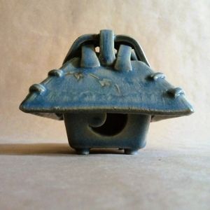 Brucia incensi a forma di capanna tradizionale giapponese. Azzurro come un freddo cielo invernale all'imbrunire, ricca di dettagli, un tralcio d'edera corre sul tetto, su ogni lato c'è un'apertura diversa dall'altra.