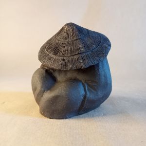 Okimono che rappresenta un pellegrino addormentato in gres nero