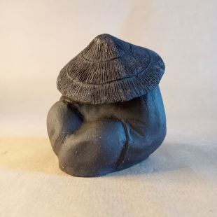 Okimono che rappresenta un pellegrino addormentato in gres nero